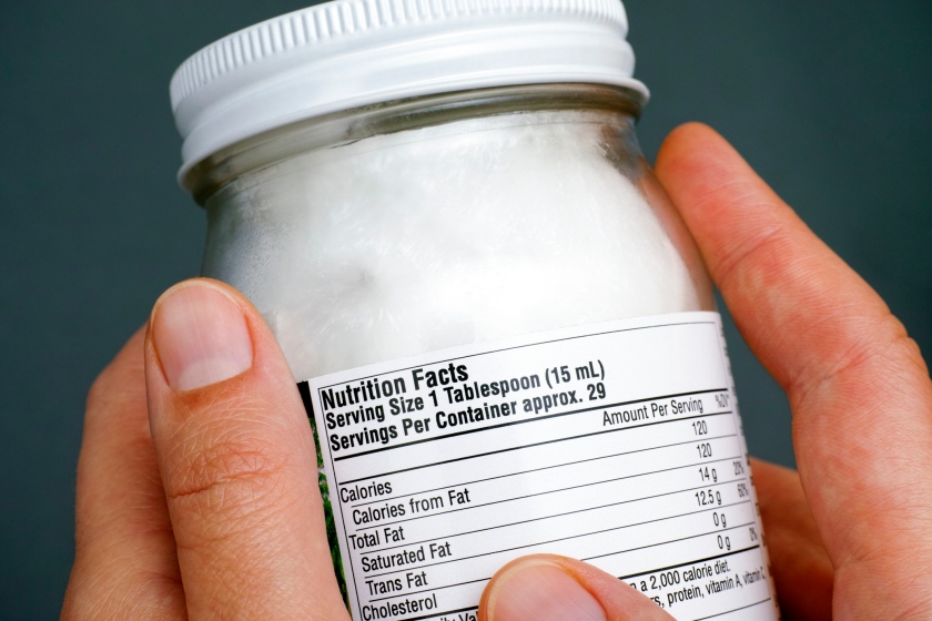 Reading nutrition facts on organic coconut oil jar